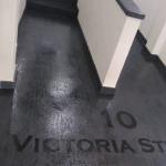 The address, 10 Victoria Street, stencilled into the black MicroCement Travertine floor