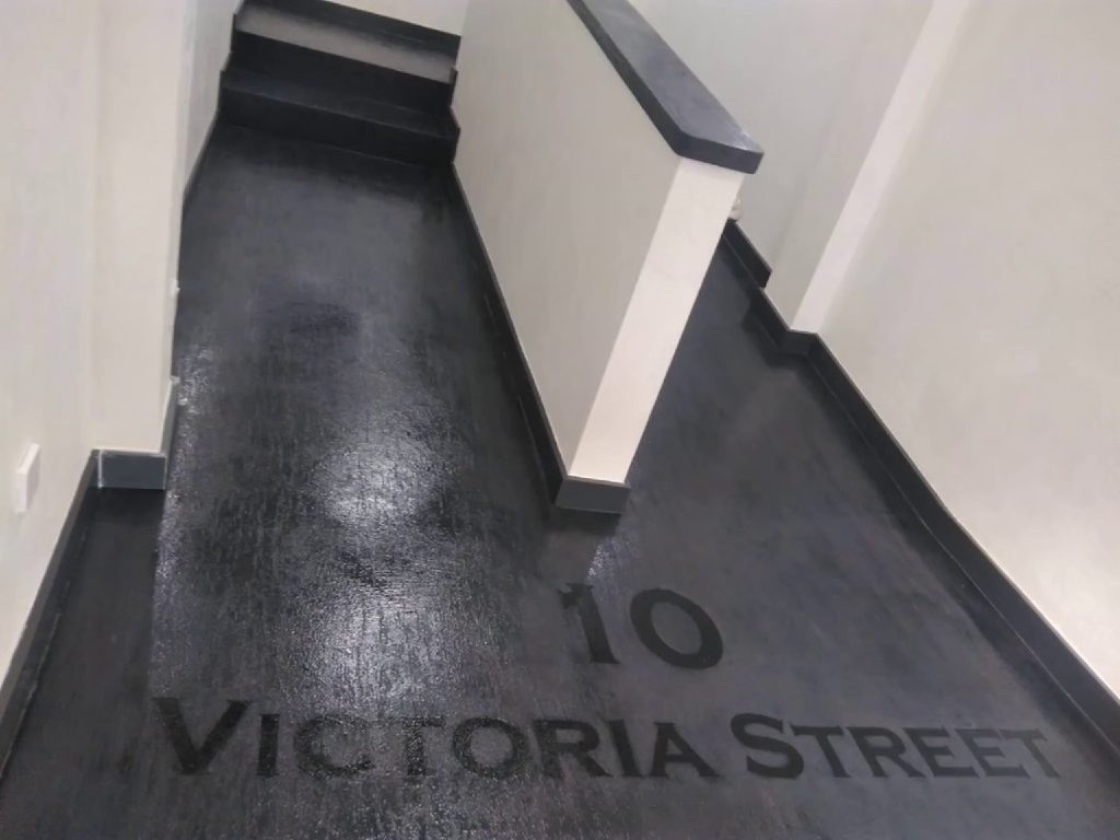 The address, 10 Victoria Street, stencilled into the black MicroCement Travertine floor