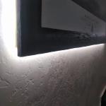 Backlighting glowing behind a MicroCement frame on the textured Marmorino wall