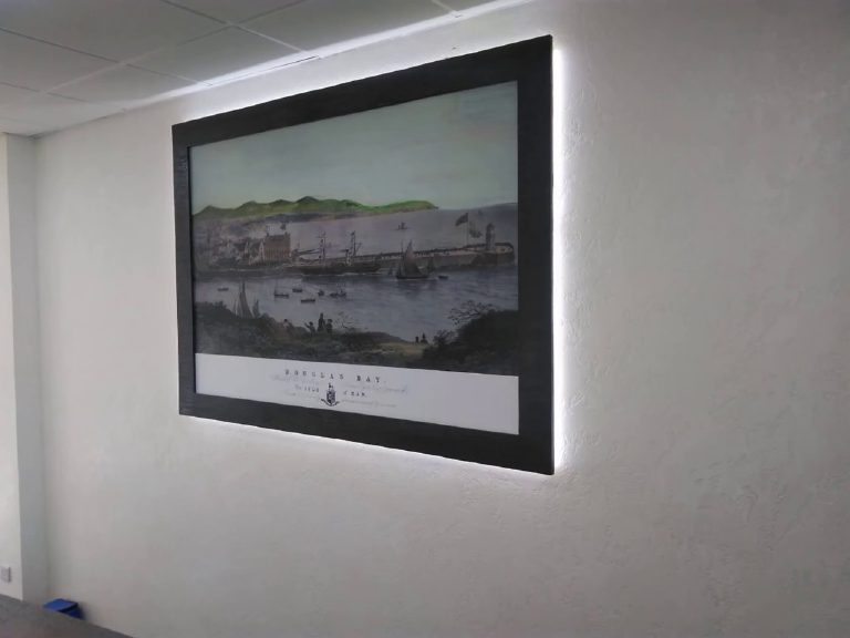 A framed bay scene glowing on the wall