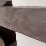 The front edge and top of the long microcement shelf above the television