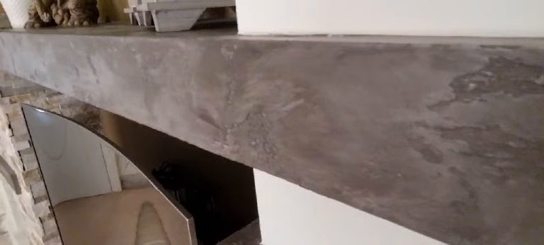 The mottled top and front edge of the shelf above the television