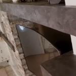 A microcement shelf ending in a squared return against the white plaster