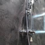 Traditional chrome shower fittings against polished charcoal MicroCement