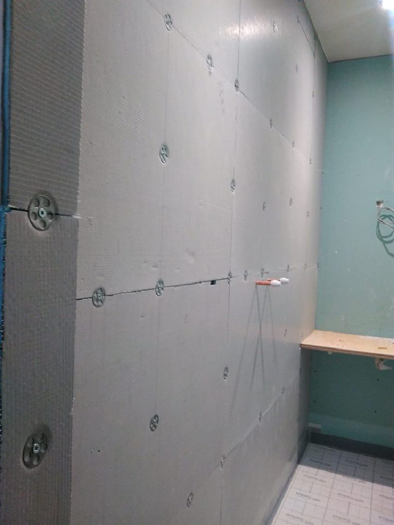 Cement backer board lining the shower wall before coating