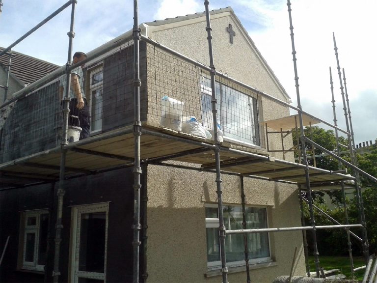 White pebbledash gable with black cross