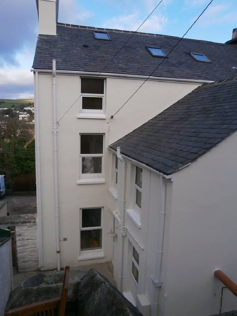 The rear elevation with its chimney and sash windows, the valley behind