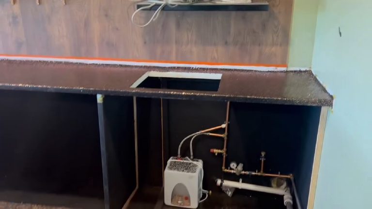 The sink cut-out in the back bar top with the plumbing still open below