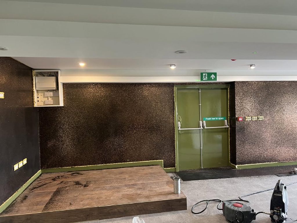 The feature wall carried across the room and round the fire door