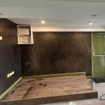 The feature wall carried across the room and round the fire door