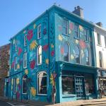The corner building on Parliament Street painted in a turquoise floral mural, seen from the street junction