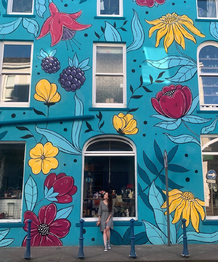 Close view of the mural on the ground and first floor with a person standing against the wall