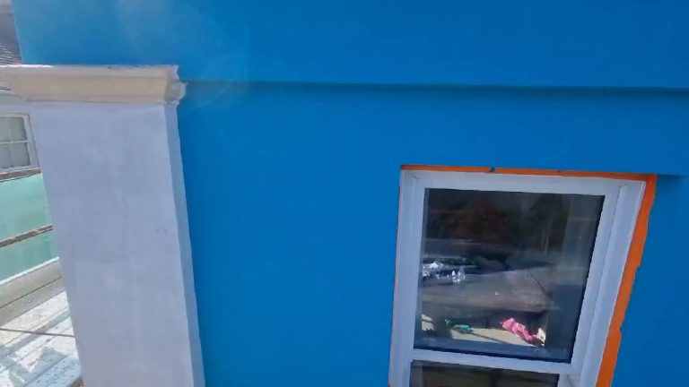 The turquoise render running up to the white painted pilaster at the end of the elevation