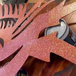 The whole phoenix — crest, arched neck, swept wing and long tail feathers — in rose glitter