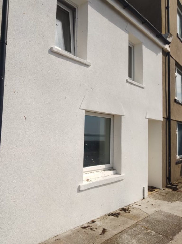 The side wall in finished cork render, seen at an angle, with seaweed on the wall and the flags below