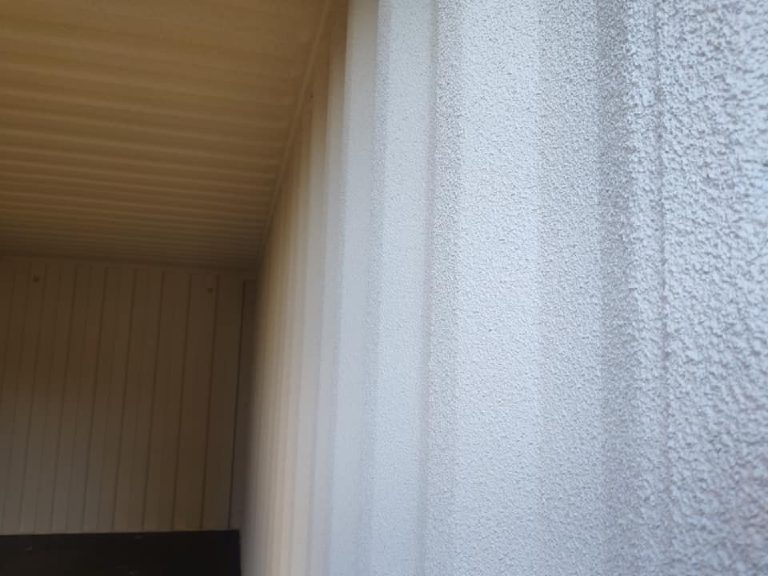The corner at the container doorway, sprayed cork on the outer face and the coated interior beyond