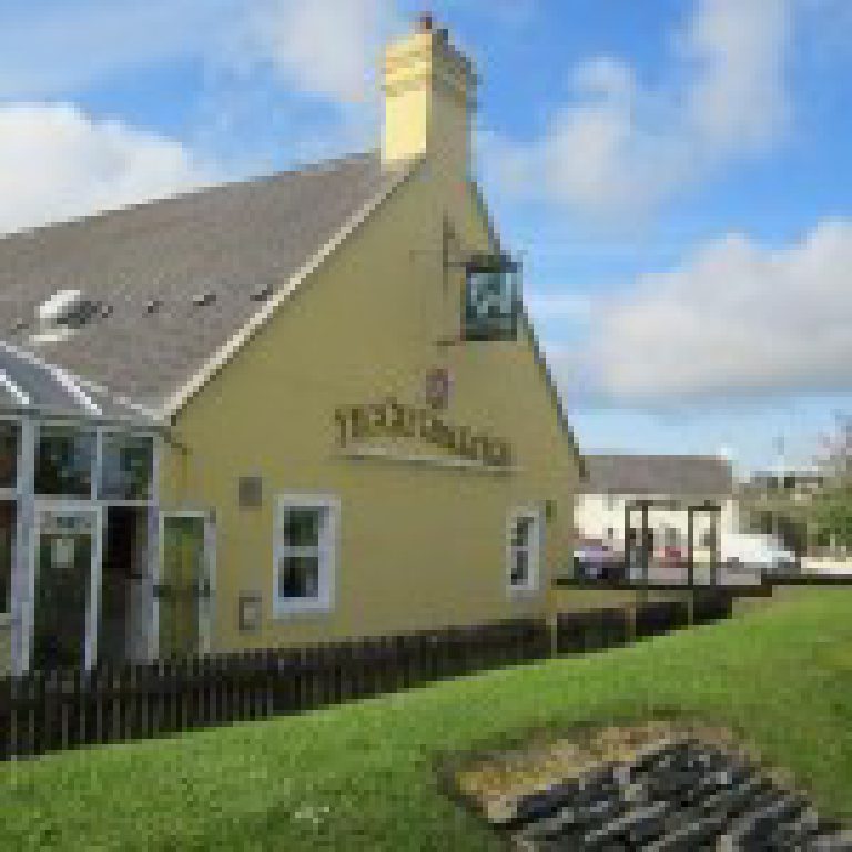The pub before the work, painted yellow with the hanging sign out at the gable end