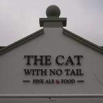 The pub name in raised lettering across the finished gable, ball finial above