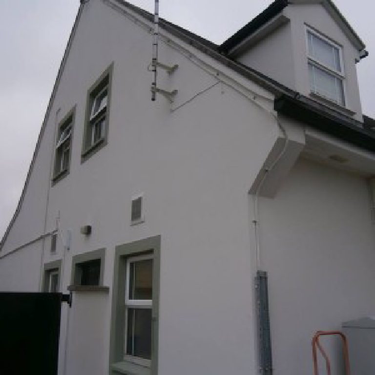 The two storey end of the building, render taken round the corner past the downpipe