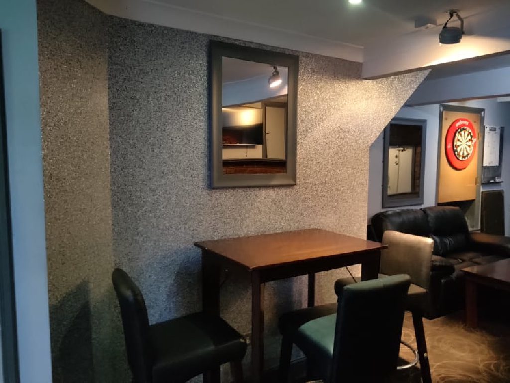 The finished corner of the bar in grey and silver Ilumitextra, with a table and stools back in place