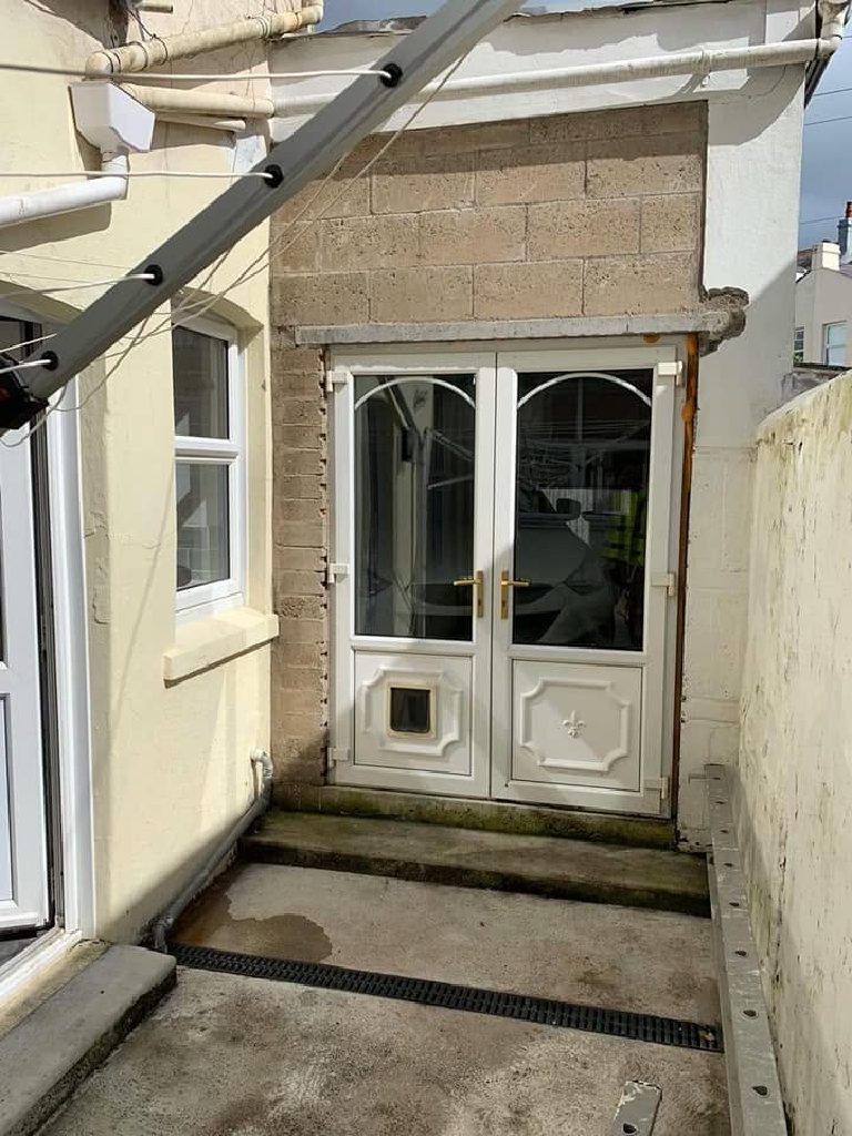 Bare blockwork above the rear doors before the work