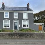 The front of the house after the thin coat render, in an even grey silicone top coat