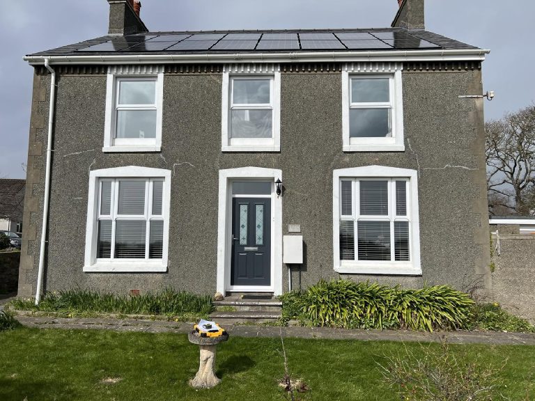 The front of the house before the work, in old grey dash with cracks under the windows