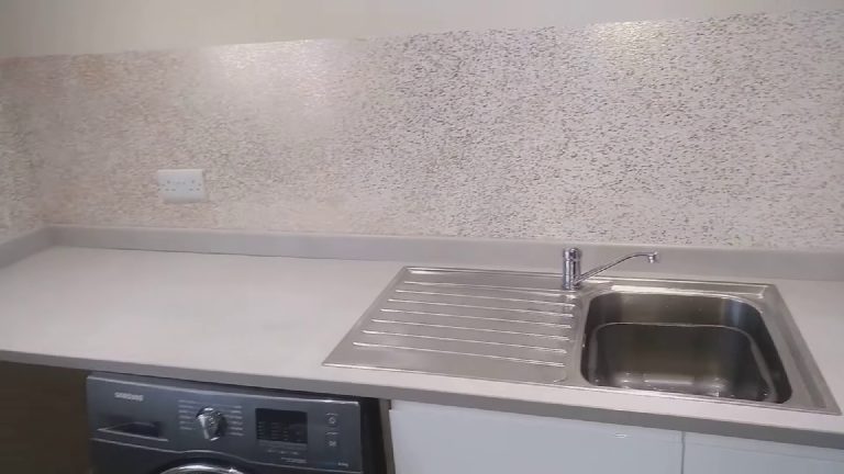 The utility worktop and sink against the glitter wall