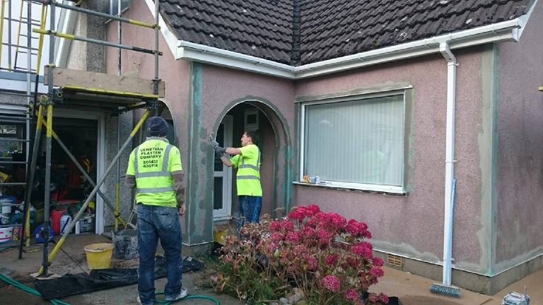 Setting exterior corner beads around the porch arch — straight edges start here.